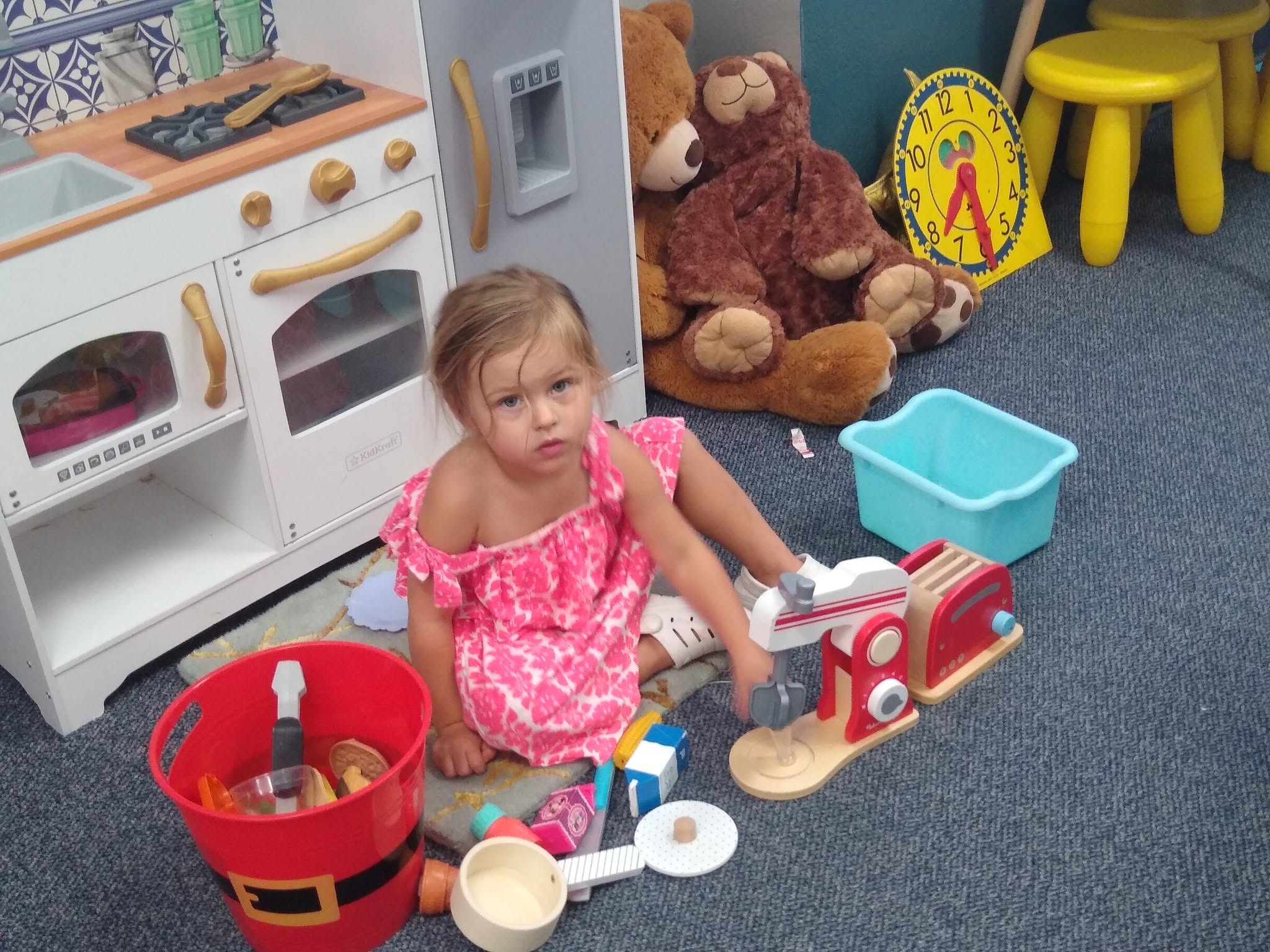 A toddler playing in the play kitchen